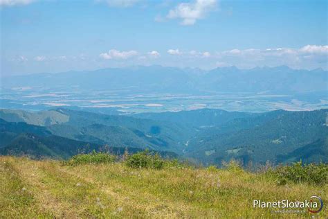 Panoramatický pohľad na hrebene Nízkych Tatier z Veľkého Boku, s Malou Fatrou v diaľke.