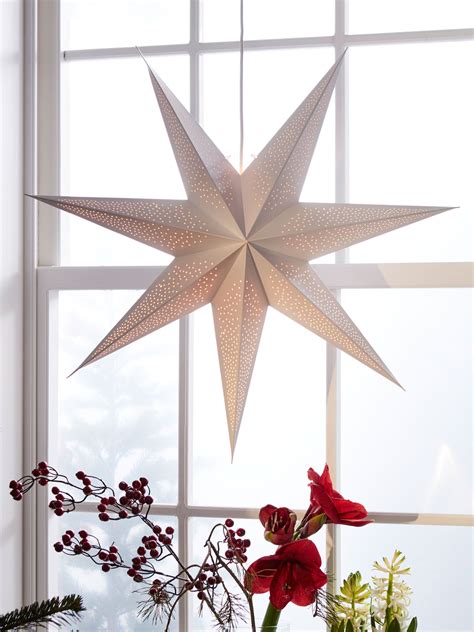 Vianočná hviezda (Poinsettia) s ozdobami na sviatočnom stole