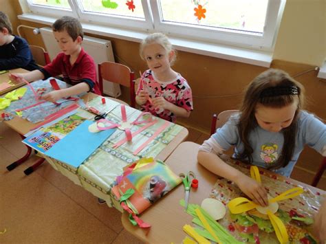 Dieťa vyrába darček z farebného papiera a gombíkov