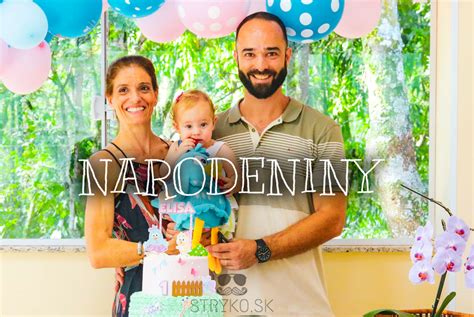 Rodičia s dieťaťom oslavujú narodeniny, fúkajú sviečky na torte.