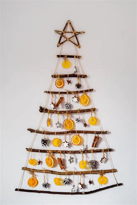 Inšpiratívna fotografia vianočného stromčeka zdobeného sušenými plátkami pomarančov, škoricou a prírodnými materiálmi.