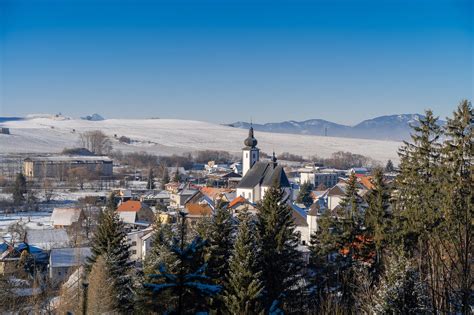 Zimná panoráma Jánskej doliny s drevenými chatami a zasneženými vrchmi hôr