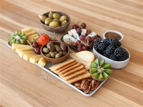 Štýlové servírovanie jednohubiek a syrových variácií na drevených podnosoch