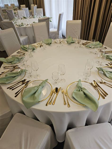 Svadobný stôl s bordovými obrusmi a zlatými svietnikmi