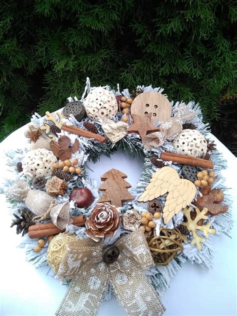 Dekoratívny črepník vyplnený čečinou a prírodnými ozdobami, s umiestnenou adventnou sviečkou.