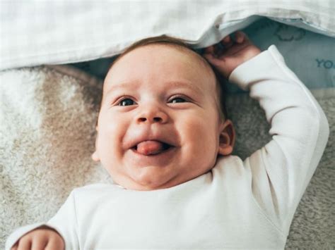 Dieťa s radostným výrazom tváre pri rozbaľovaní vianočného darčeka