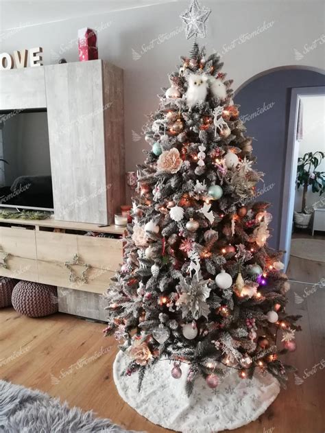 Zasnežený vianočný stromček v obývačke s elegantnými striebornými a bielymi ozdobami