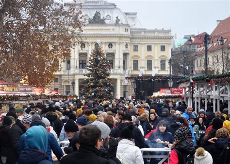 Slávnostne osvetlené Hviezdoslavovo námestie počas Silvestra s ľuďmi a pódiom.
