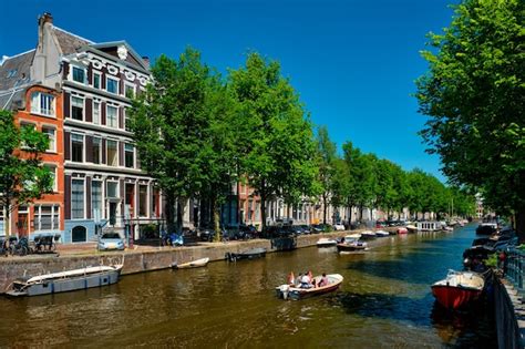 Zimná atmosféra Amsterdamu s vysvietenými kanálmi a domami