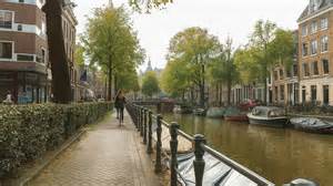 Scéna z ulice Amsterdamu s bicyklami a kanálmi