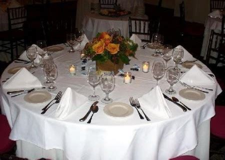 štýlovo prestretý svadobný stôl s jednoduchou kvetinovou výzdobou a menu kartou