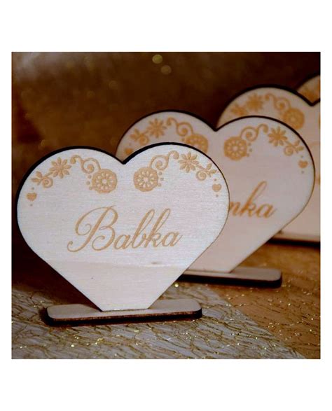 Skladba svadobného stola: vintage vázy, krajkové obrúsky, drevené menovky a sviečky v mosadzných svietnikoch.