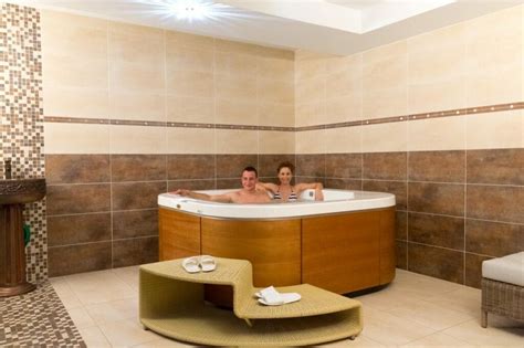 Muž relaxujúci v kúpeli plnom pivných ingrediencií