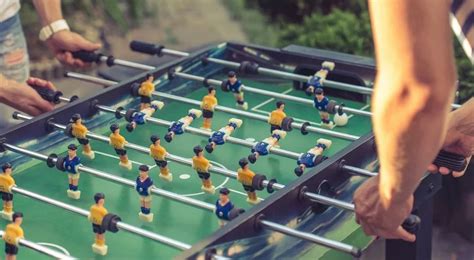 Muži hrajúci stolný futbal