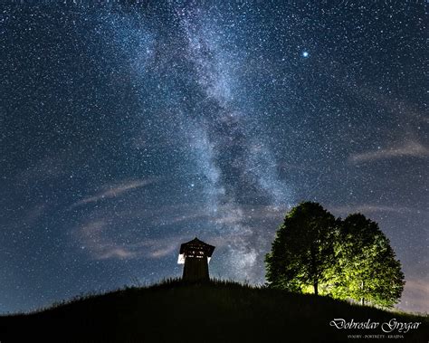 Nočná fotografia Pozdravu Slnku s aktívnou farebnou svetelnou show a siluetami ľudí