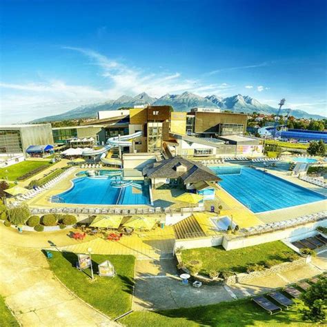 fotografia vonkajších bazénov AquaCity Poprad s výhľadom na zasnežené štíty Vysokých Tatier