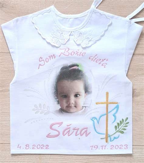 Detailná fotografia vyšívanej bielej krstnej košieľky s personalizovaným menom a dátumom