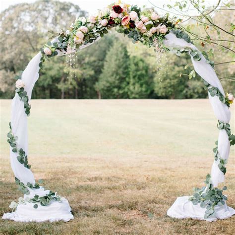 Svadobný oblúk zdobený kvetmi a zeleňou v prírodnom prostredí