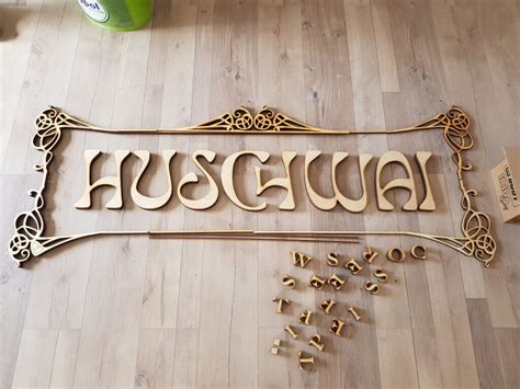 Detail drevených štipcov s menovkami a dekorované 3D písmená na svadobnom stole