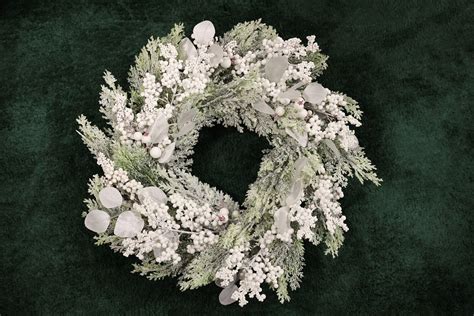 Inšpirácia pre vianočný veniec na vchodových dverách s prírodnými prvkami ako šišky a čečina.