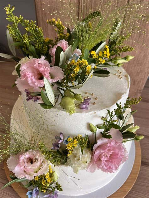 Svadobná tvarohová torta zdobená čerstvým ovocím a jedlými kvetmi