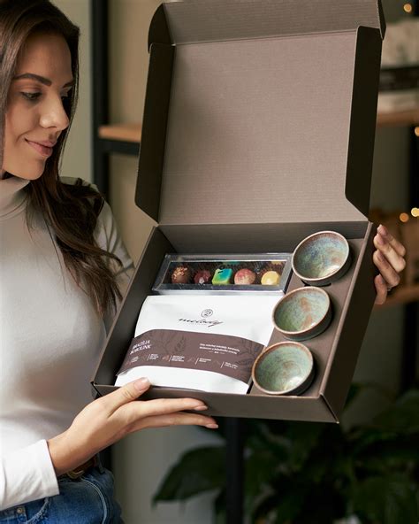 Žena otvárajúca vianočný darčekový box plný zdravých pochúťok.