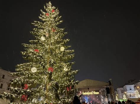 Ilustrácia vianočného námestia s rozsvieteným stromčekom a ľuďmi